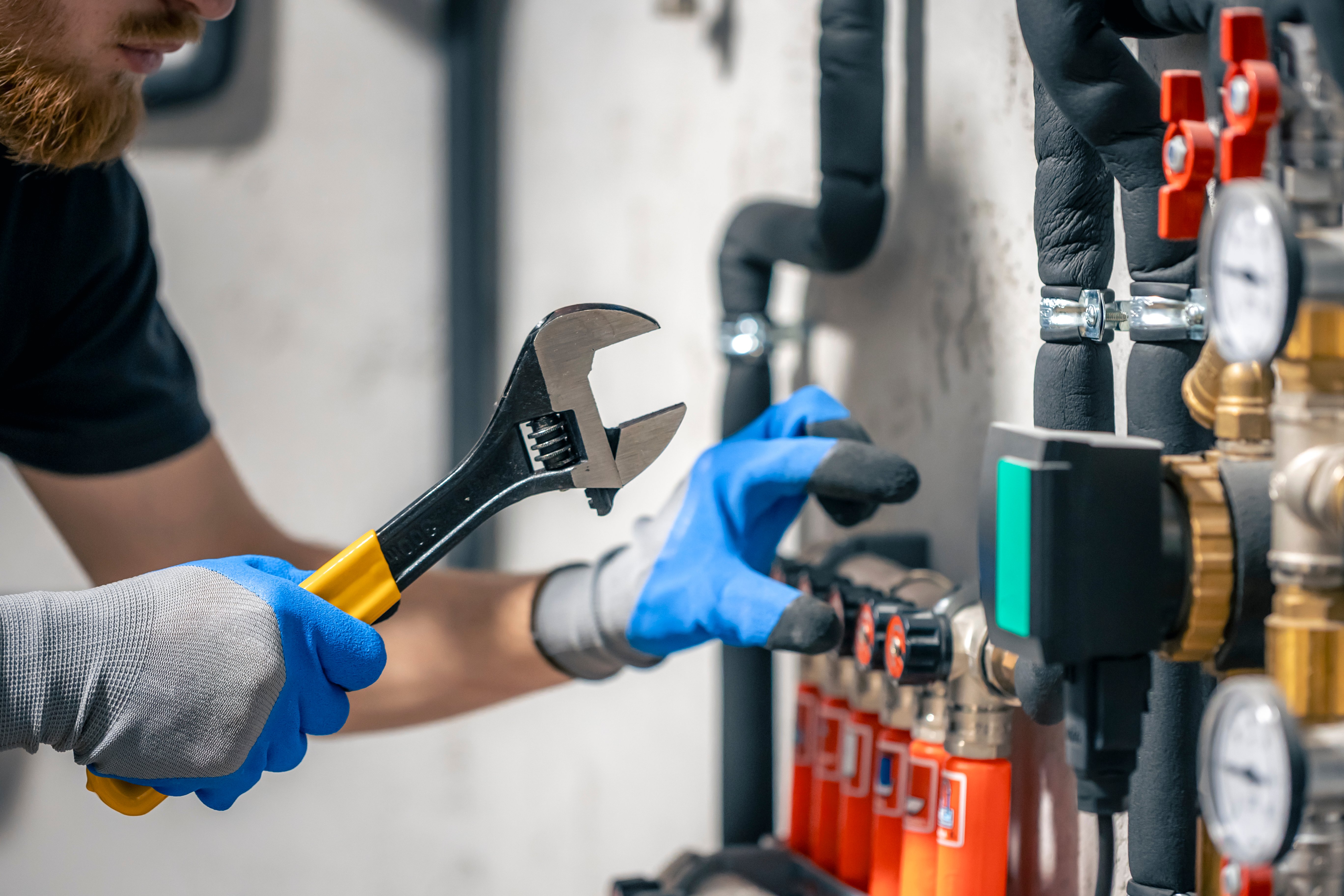 man-installs-heating-system-house-checks-pipes-with-wrench